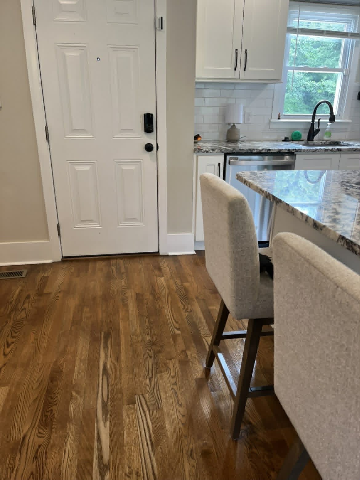 Clean kitchen with island and upholstered barstools