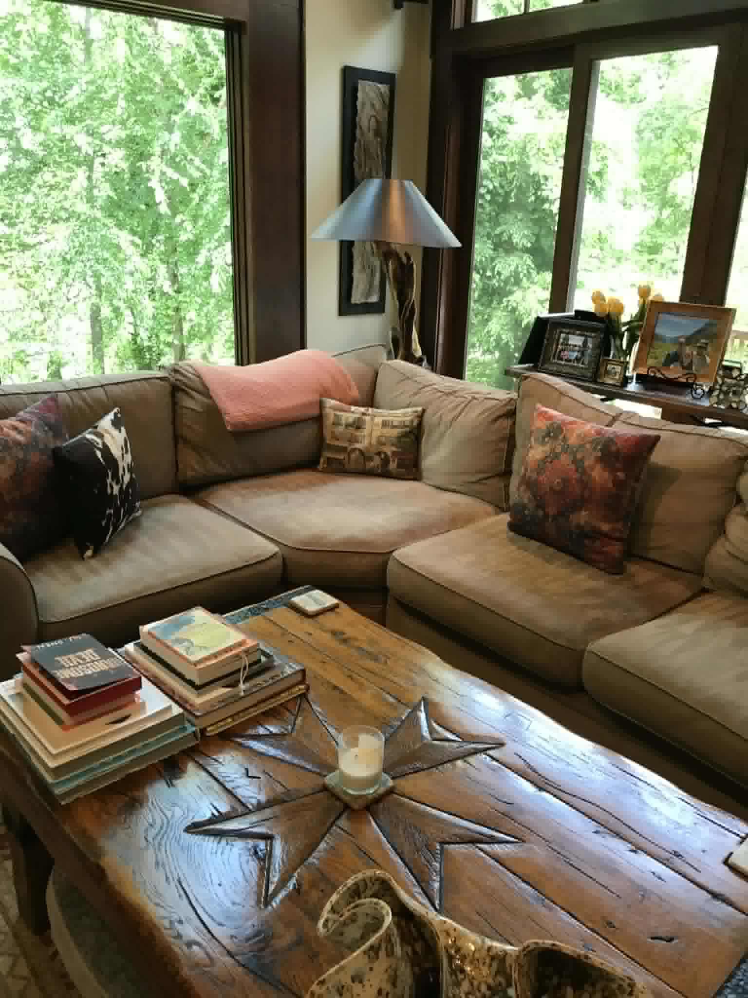 Rustic cabin living room with tan sectional and large windows