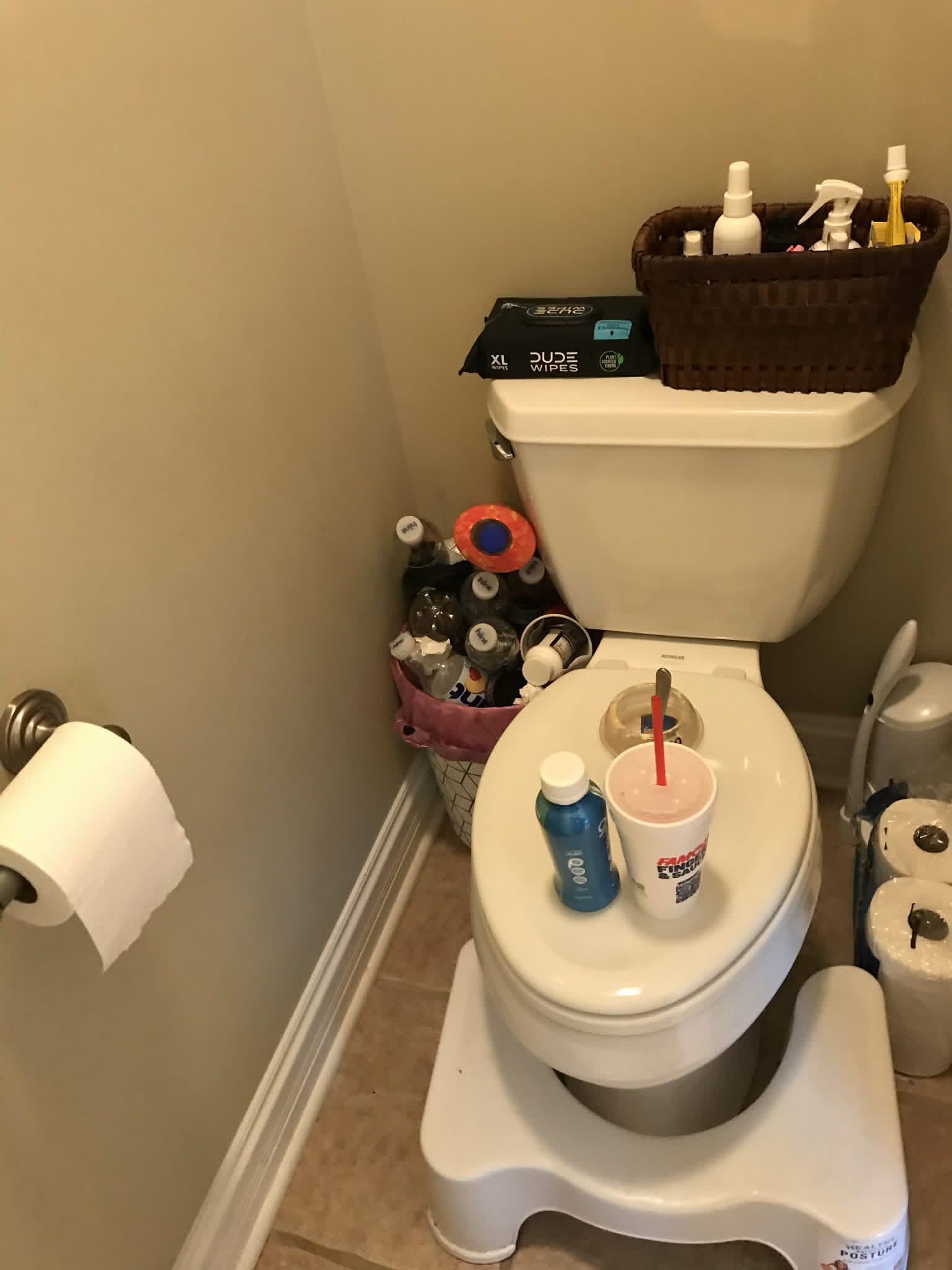 Bathroom toilet before — drinks on lid, clutter on floor