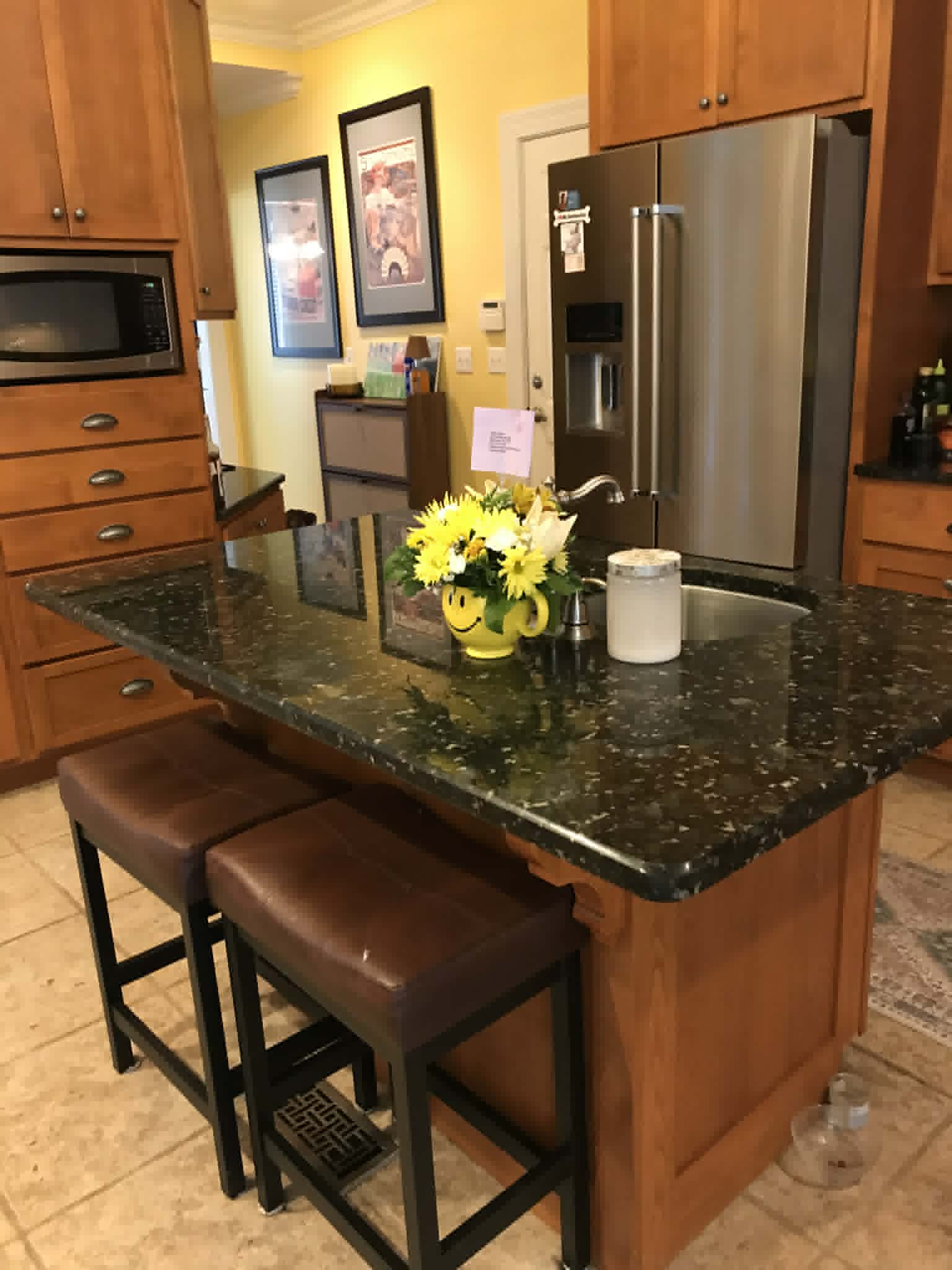 Kitchen with dark green granite island and honey oak cabinets