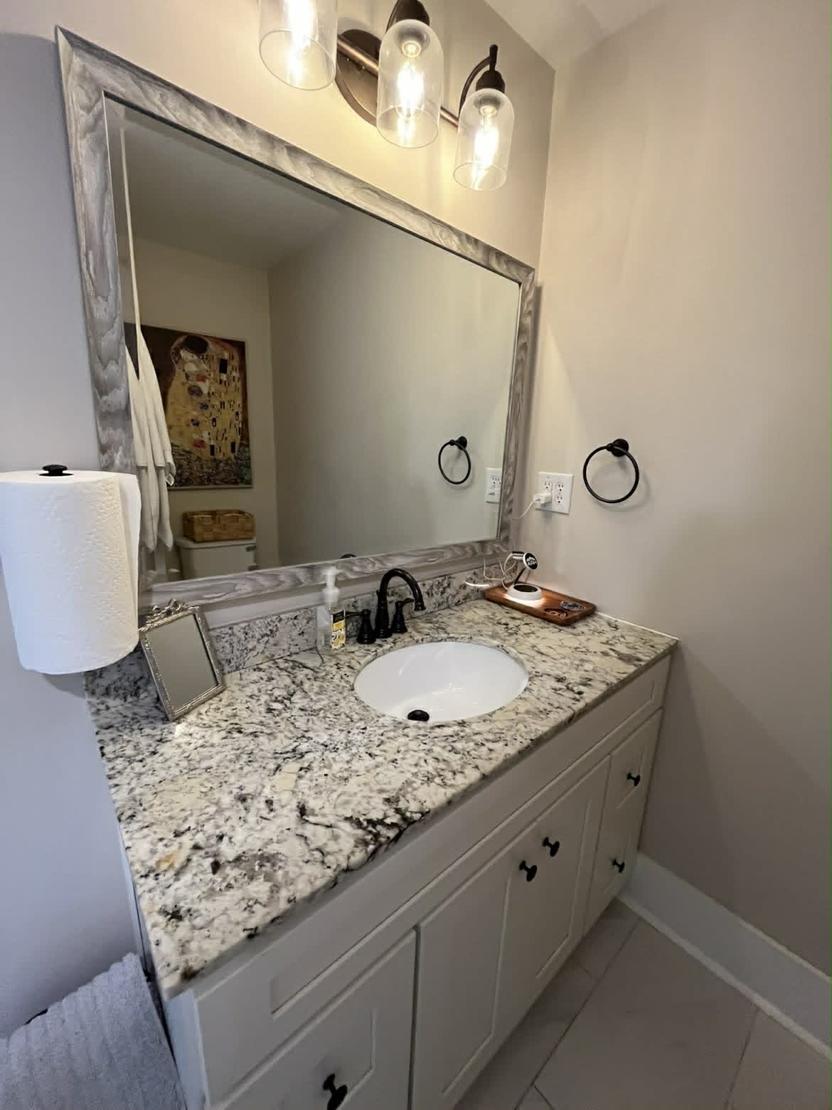 Clean white farmhouse bathroom vanity with black faucet